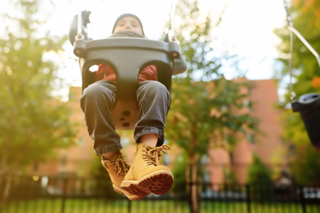 Cute little boy having fun on outdoor playground. Spring/summer/autumn active sport leisure for...