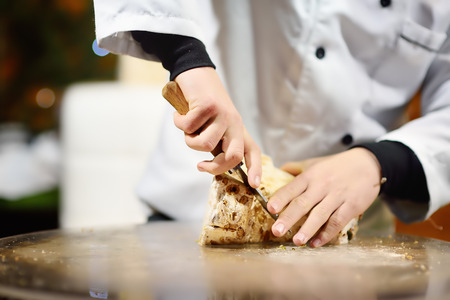 Person cuts nougat at the market. Typical European local farmer marketの写真素材