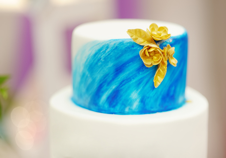Elegant sweet table set wedding cake with blue cake with golden flowers and cupcakes on wedding or event party. Sweet table on wedding party.の写真素材
