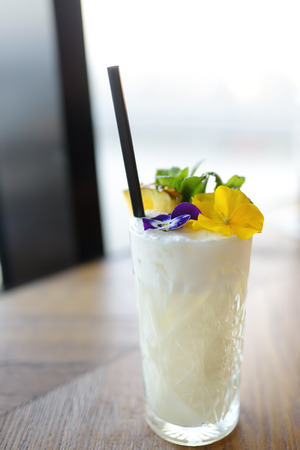 Pina colada cocktail decorated with flowers and mint. This beverage making from pineapple, coconut cream and rum. National drink.の写真素材