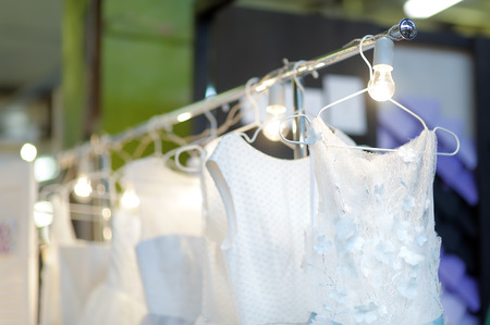 Few elegant wedding, bridesmaid ,evening, ball gown or prom dresses on a hanger in a bridal shop. Fashion for beautiful brides.の写真素材