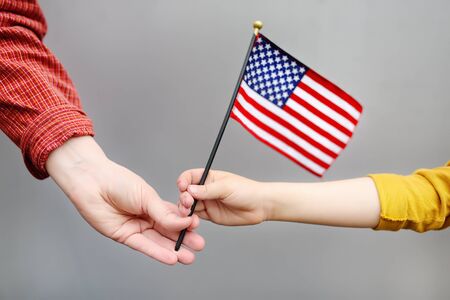 Young woman and little child holding american flag. Independence Day concept. Family together