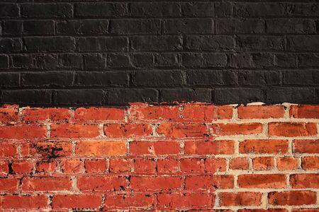 Stylish background of wall with black and red brick. Close-up photo of brick surface textureの写真素材
