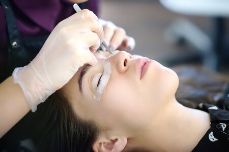 Beautician making eyelash lamination procedures. Modern eyelash care treatment procedures -...