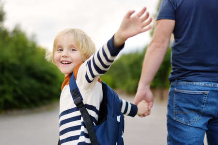 Little boy with his father going to school after summer break. Education for little kids. Back to...