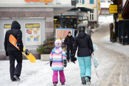 Saas Fee, Switzerland - February 4, 2020: Tourists walking on street of mountain resort town in Switzerland, Europe. Winter family vacation concept in Alps. Ski resort.のeditorial素材