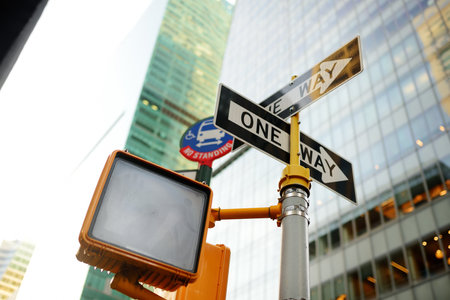 Different road signs with skyscrapers on background in New York City, USA. Traffic sign one way and...