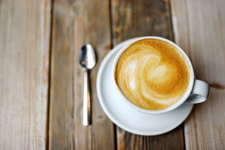 A cup of fresh cappuccino coffee on a wooden table in a cafe or restaurant. Coffee break. Catering.の写真素材