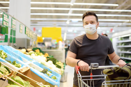 Man wearing protective medical face mask shopping in supermarketの写真素材