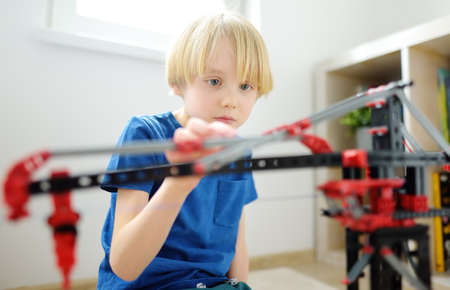 Preschooler boy playing with big construction building crane toy at home. Kids leisure activity. Entertainment for children indoors. Offline games. Creative game, development of imagination.の写真素材