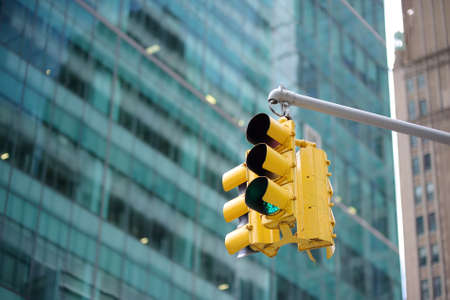 Yellow Traffic Light on background of skyscrapers, Manhattan, New York, USA. Green stop signal.の写真素材