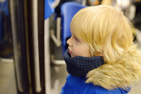 Little boy in a cabin of subway or tram car. Child passenger of comfortable transport of big city....