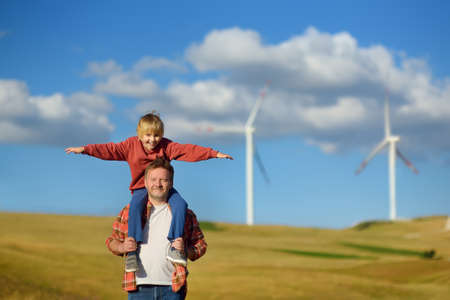 Eco activists man and child on background of power stations for renewable electric energy production. people and windmills. Wind turbines for electricity generation. green concept energyの写真素材