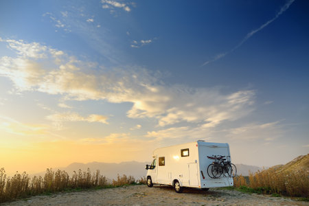 Parked big modern camper motorhome. Family vacation travel RV. Bicycles attached to a caravan....