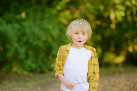 Portrait of cheerful smiling preschooler child during summer holidays on sunny day. Concept of freedom, happy childhood and limitless possibilities. Vacation for family with kidsの写真素材