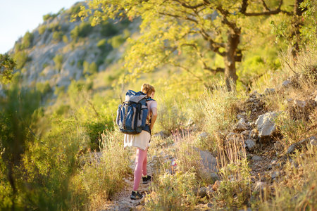 Young woman hiking in countryside. Concepts of adventure, extreme survival, orienteering. Single travel. Backpacking hikeの写真素材