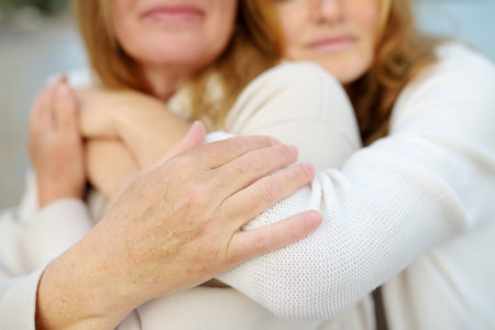 Redhead senior mother and her beautiful adult daughter are walking together and laughing. A happy meeting of a mom and her grown child. Family relationships between adult children and parentsの写真素材