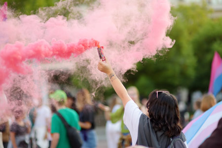 Podgorica, Montenegro - October 8, 2022: Activist woman holding a pink smoke bomb during the Ten Pride Parade. Fight for equal rights. Rainbow flag is symbol of Lgbt communityのeditorial素材