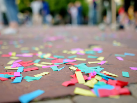 Multicolour paper ticker-tape lies on the ground after celebration of wedding, birthday, carnival, lgbt pride parade or outdoors festival. After party.の写真素材