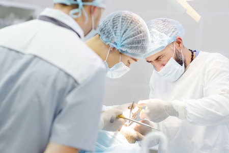 Surgeons and nurse during a dental operation.Anesthetized patient in the operating room.Installation of dental implants or tooth extraction in the clinic. General anesthesia during orthodontic surgeryの写真素材