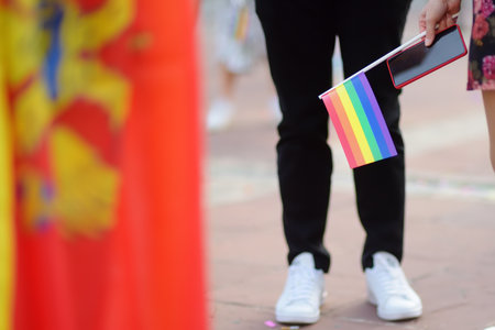 Activists are holding rainbow flag and Montenegro flag on the march on the city street during the Pride Parade. Fighting for equality os sexual minorities. Rainbow banner is a symbol of lgbt communityの写真素材