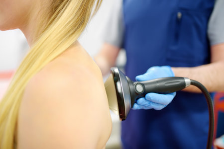 Close up of extracorporeal shockwave therapy in beauty salon. Physical therapy for neck and back...