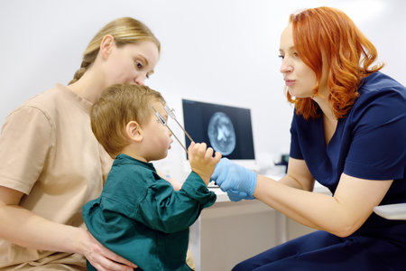 Baby and his mother are being seen by a pediatric neurologist in medical clinic. Doctor conducts...