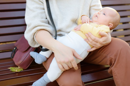 Sweet 2 month old infant lying in mommy's arms. Portrait of beautiful newborn boy or girl baby....