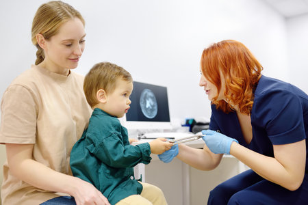 Baby and his mother are being seen by a pediatric neurologist in medical clinic. Doctor conducts...