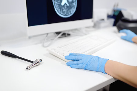 Neurologist is at an appointment in office of modern clinic. Doctor sitting at desk and studying an...