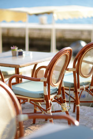 Tables of street restaurant on the embankment of Perast, Montenegro. An outside veranda of a...