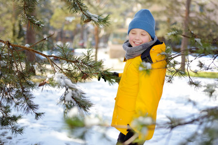 Preteen boy having fun during vacation in european Alps. Child dressed in warm clothes, hat, hand...