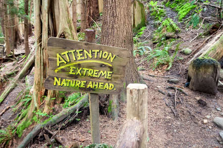 A humorous sign along a hiking path through old-growth forest in Capilano Suspension Bridge Park, North Vancouver, British Columbia, Canadaの写真素材