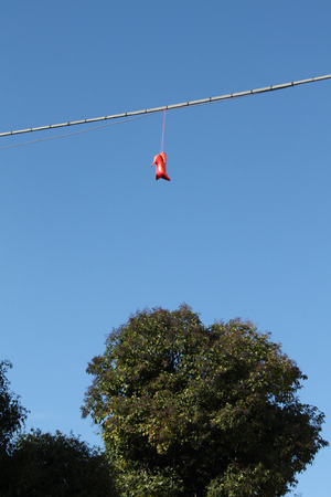 Red shoes hanging on a electric wire - Rome Italyの写真素材