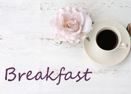 Breakfast text on a vintage table a cup of black coffee and a flowerの写真素材