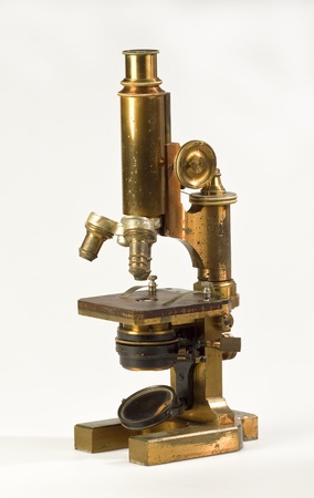 Old brass microscope on white backgroundの写真素材