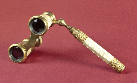 Nacre and brass opera glasses on oxblood red backgroundの写真素材