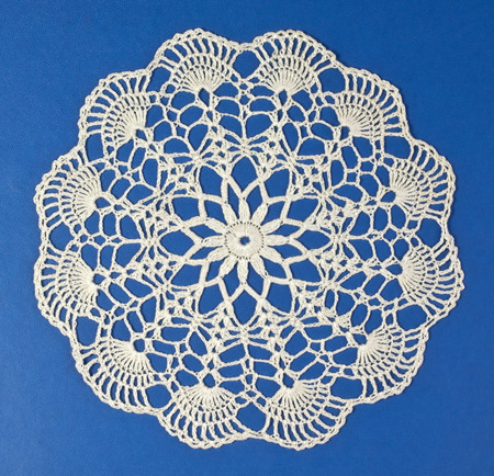 Handmade doily on blue background