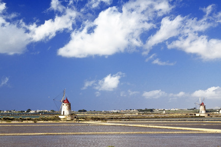 Salt evaporation ponds and two windmills in Stagnone lagoon, Marsala, Sicilyの写真素材