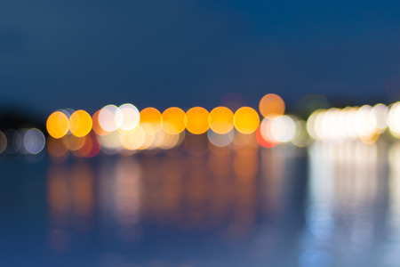 Abstract blurred bokeh at twilight time with reflection on river