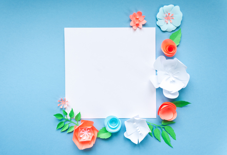square frame with color paper flowers on the blue background. Flat lay. Nature conceptの写真素材
