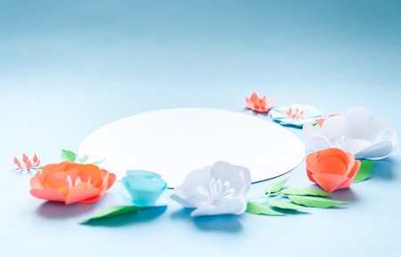 round frame with color paper flowers on the blue background. Nature conceptの写真素材