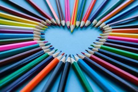 Abstract blur background. Crayon heart - Heart shape made of colored pencils on blue backgroundの写真素材