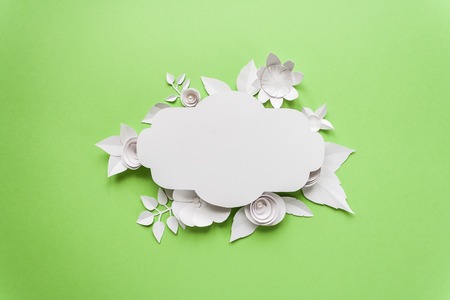 Festive flower composition with white paper flowers with greeting card on the green background. Flat lay, overhead view, top viewの写真素材