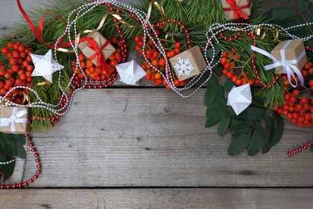 New year and Christmas background. Branches of the spruce and red ash with gifts and Christmas beads