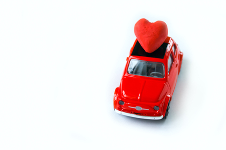 Happy Valentines day. The car carries a red clay heart. White background, isolatedの写真素材