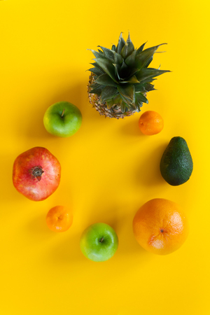 Round frame from exotic fruits on a yellow background. flat lay, top viewの写真素材