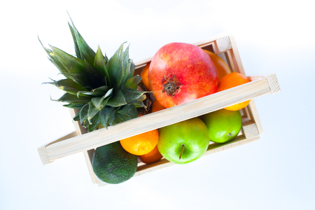 tropical fruits in wooden box on white backgroundの写真素材