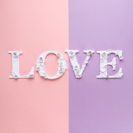 Photo inscription love made of leaves and flowers on pink and purple background. lettering. Design elements for Valentine's day.の写真素材