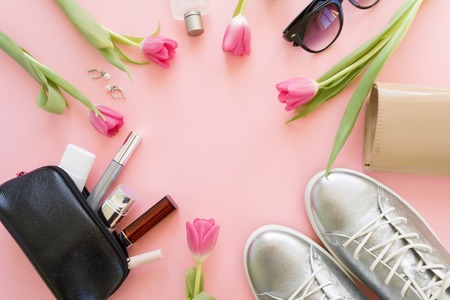 Round frame with women's accessories and a Tulip on pale pink background. selective focusの写真素材